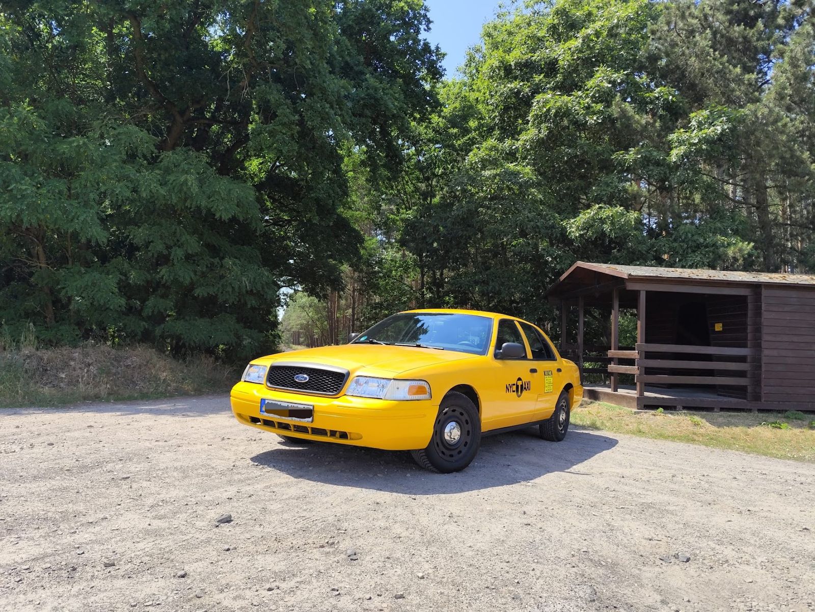 Das Taxi von vorne vor einer Holzhütte