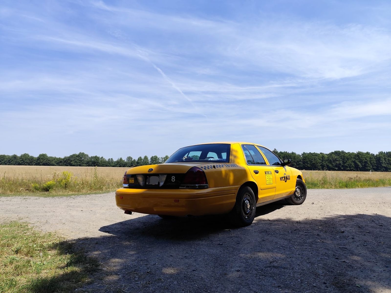 Das Taxi von hinten vor einem Feld